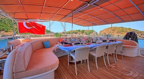 Queen Of Salmakis yacht, outdoor dining area under orange canopy overlooking harbor