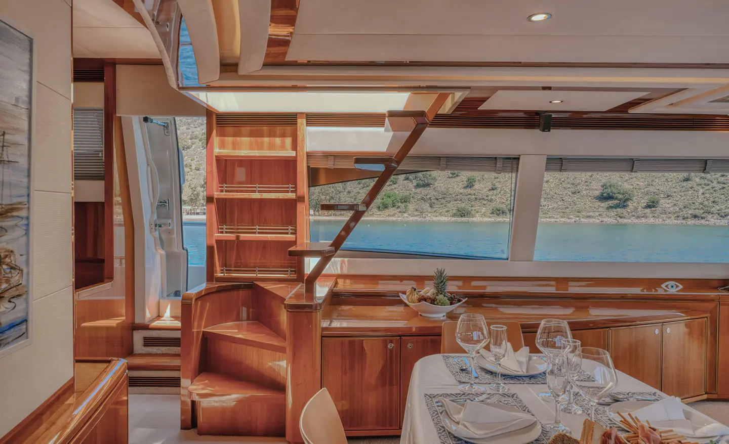 Interior of yacht Lidia saloon with table setting and stairs visible