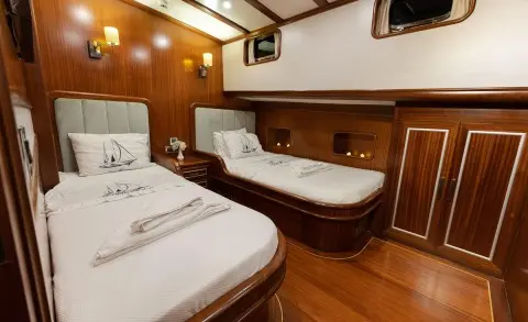 Inside cabin aboard Estrella De Mar, twin beds, polished wood panels