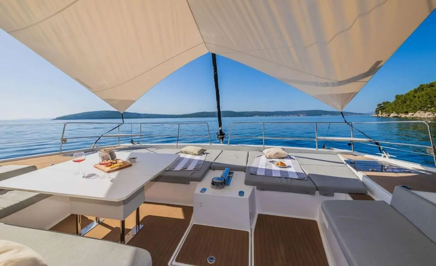 View from yacht cockpit under canopy with seating and ocean horizon at sunset