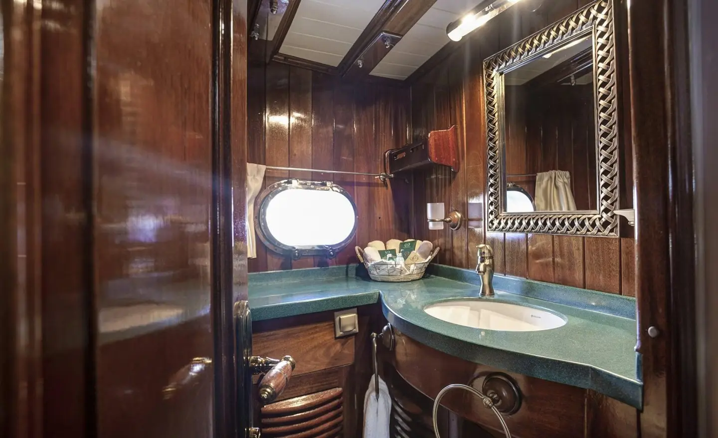 Small wooden bathroom with a bright mirror frame and sink