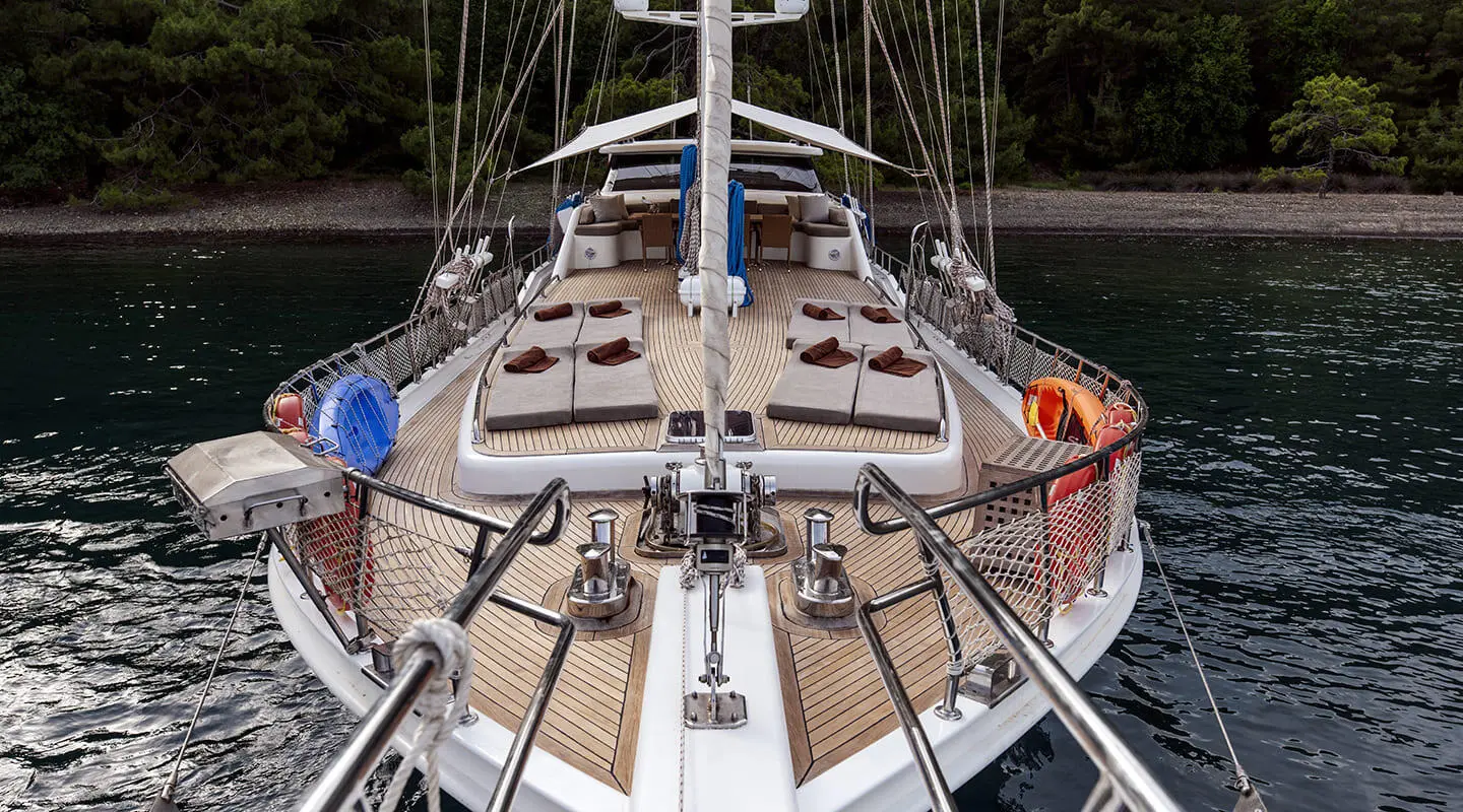 Kayhan 3 yacht bow deck shown on calm water, with seating and rigging