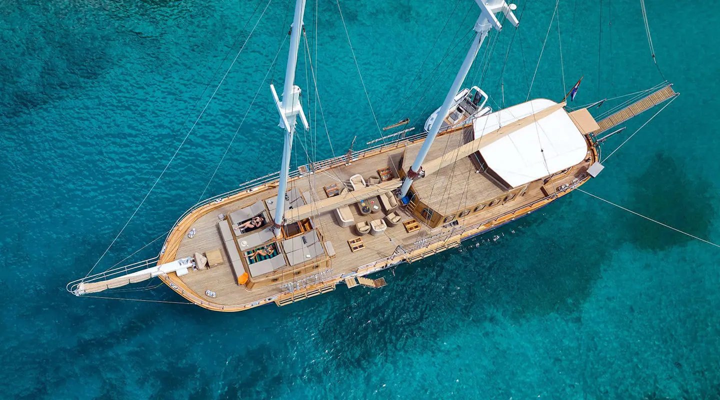 Aerial view of Libra sailing yacht on turquoise seas with teak deck and spacious lounge