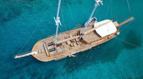 Aerial view of Libra sailing yacht on turquoise seas with teak deck and spacious lounge