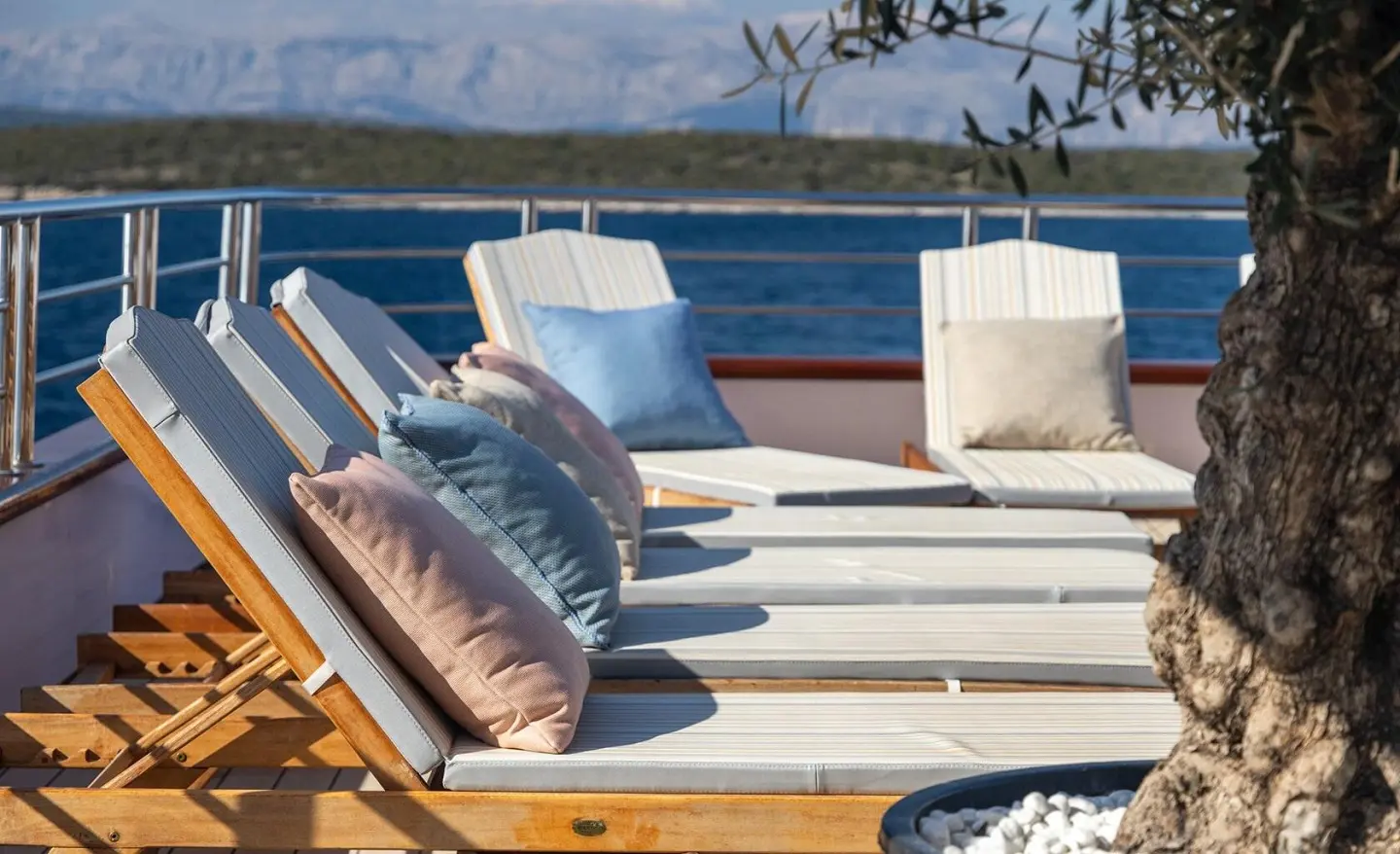 Sun loungers on an open deck with cushions and pillows