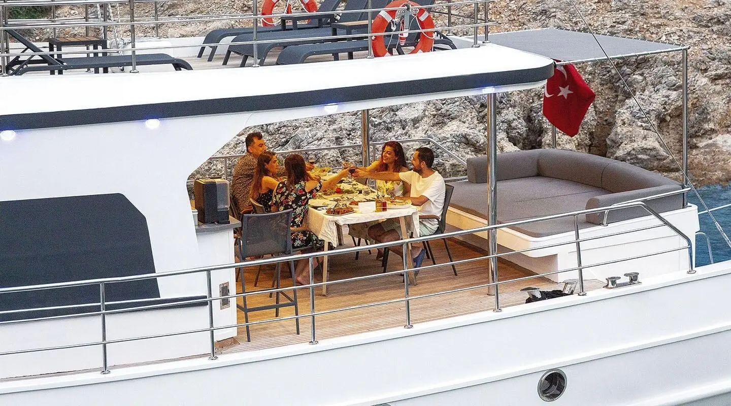 Maske 5 gulet shows an outdoor dining area with a group sharing a meal