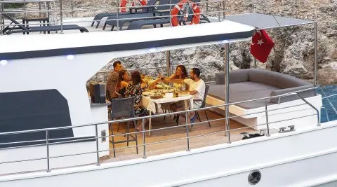 Maske 5 gulet shows an outdoor dining area with a group sharing a meal