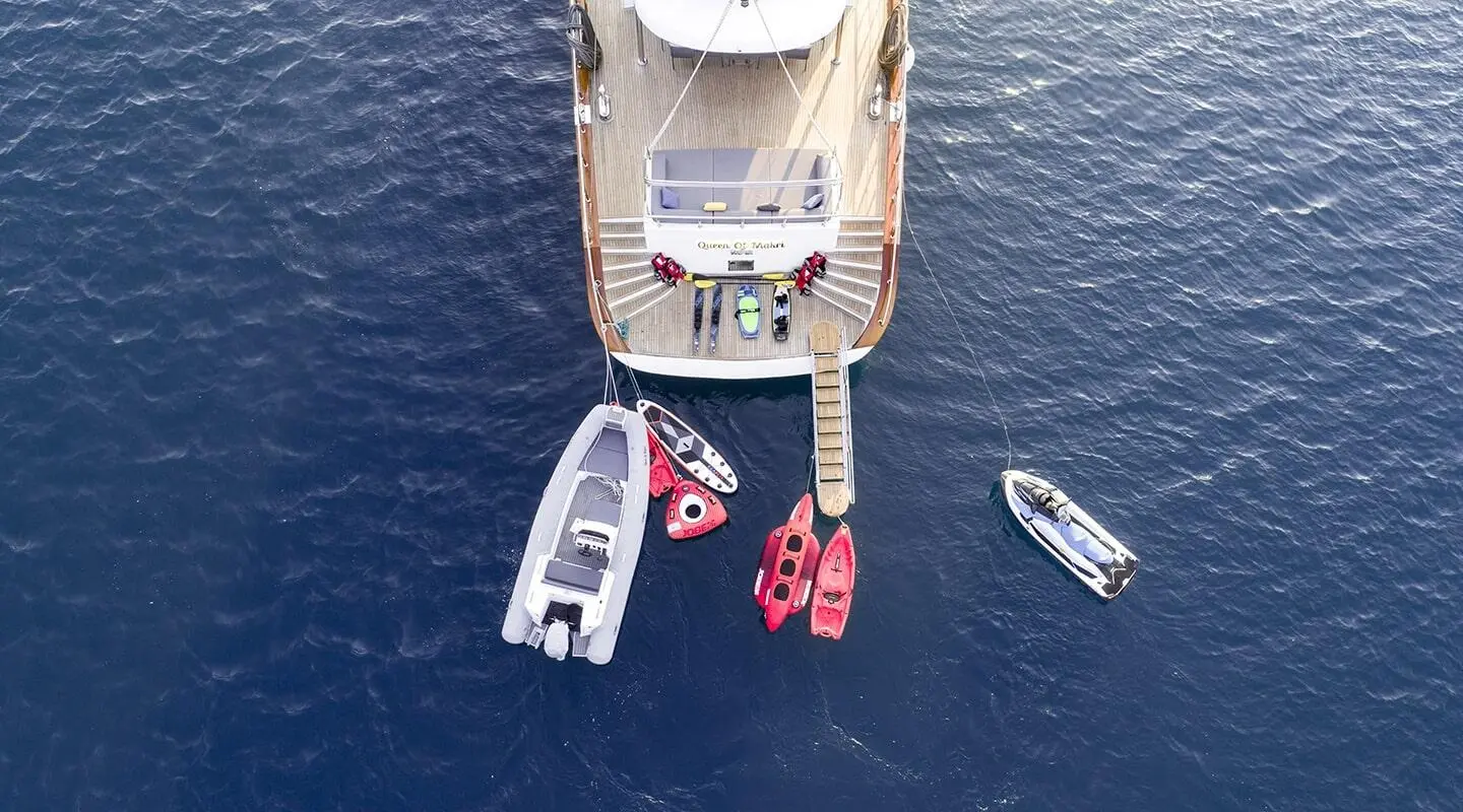 Aerial view of a luxury gulet named Queen Of Makri with boats nearby on calm sea at sunset