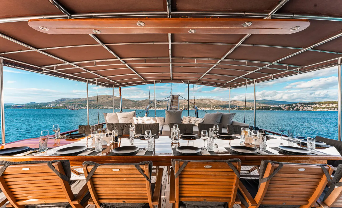 Sun loungers on a yacht deck facing calm sea at sunset, Croatia charter