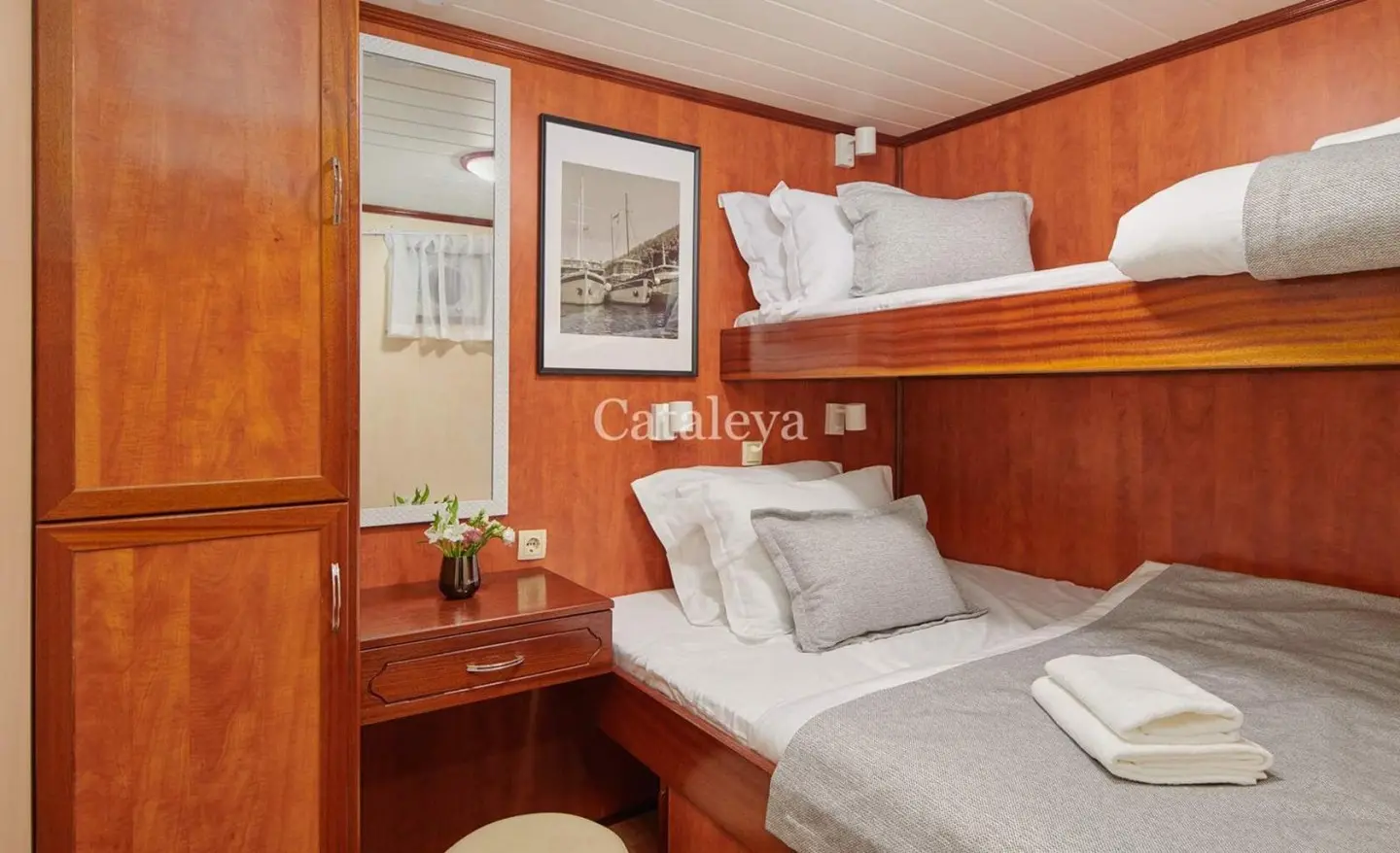 Cataleya interior: twin bunk cabins with warm wood panels and white linens