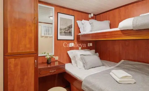 Cataleya interior: twin bunk cabins with warm wood panels and white linens
