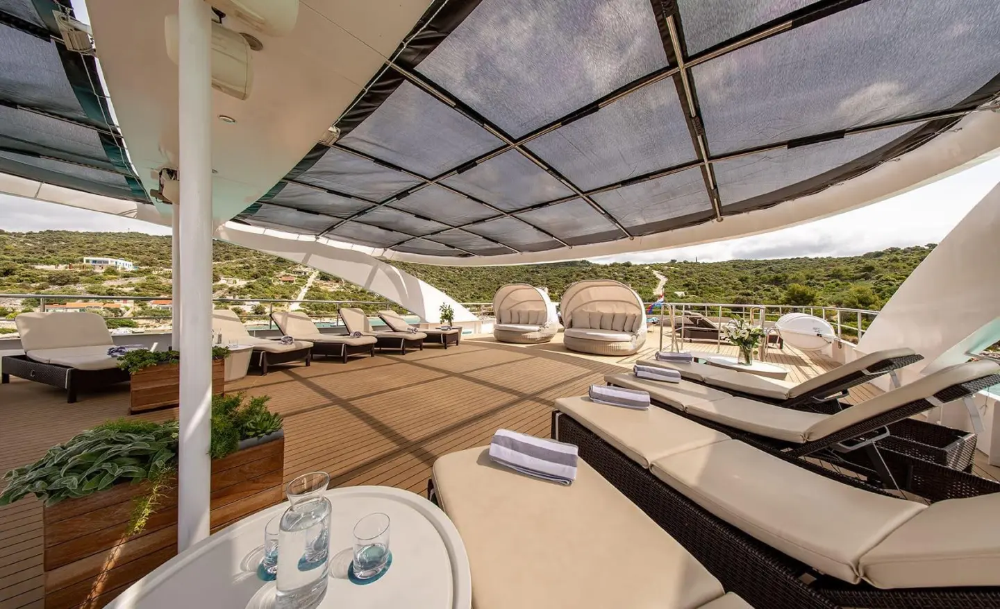 Karizma yacht sun deck at sunset with loungers and seating area