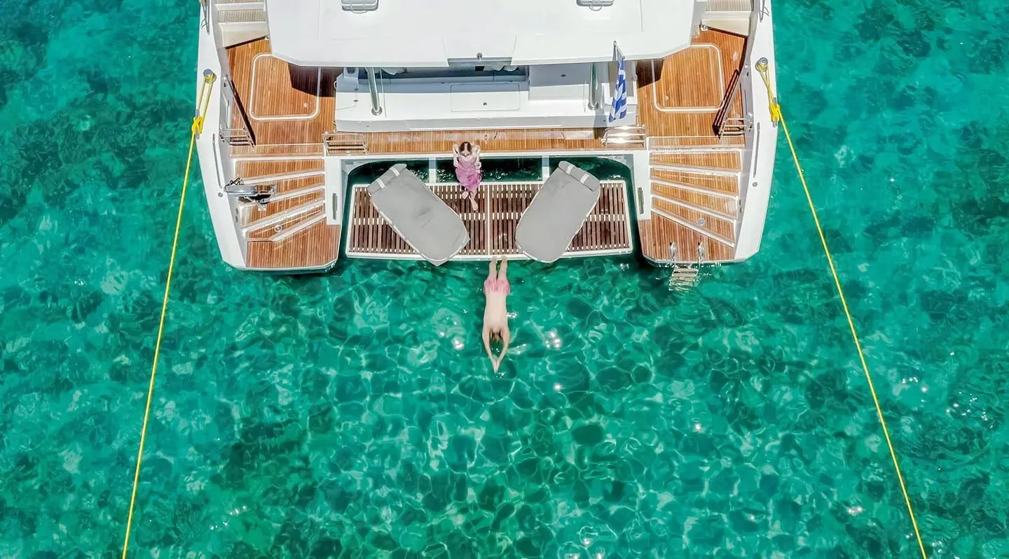 Aerial view of a yacht D2 at sea with turquoise water around stern