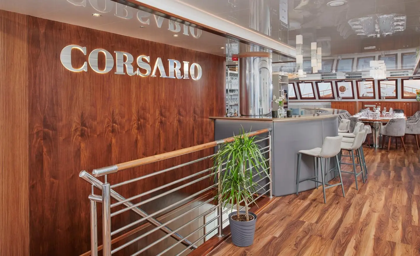 Interior view of Corsario yacht bar with wooden deck, seating, and plants