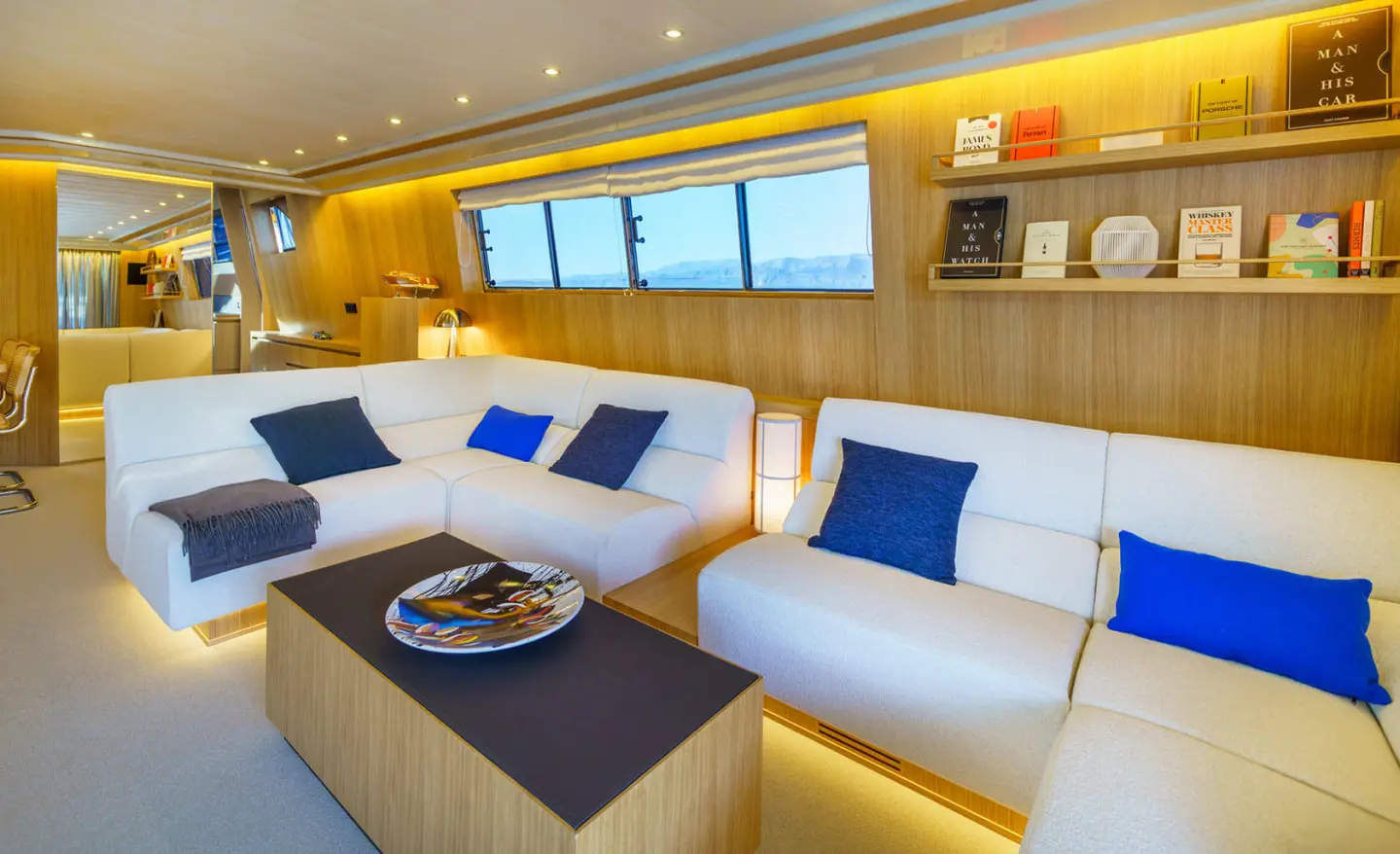 Phantom motor yacht saloon with white seating, blue cushions, and warm lighting