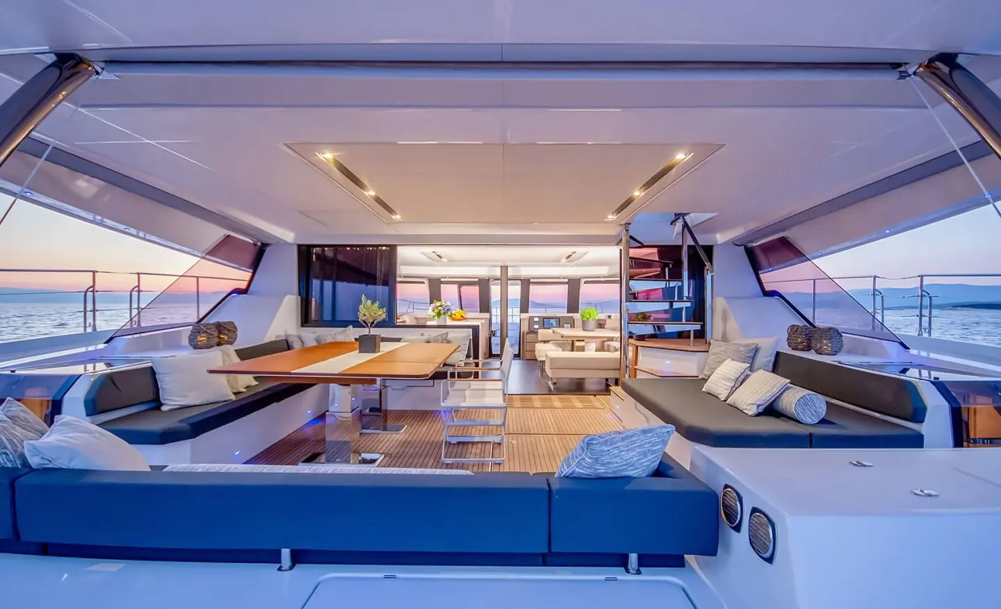 D2 motor yacht aft deck with open seating area and wooden table