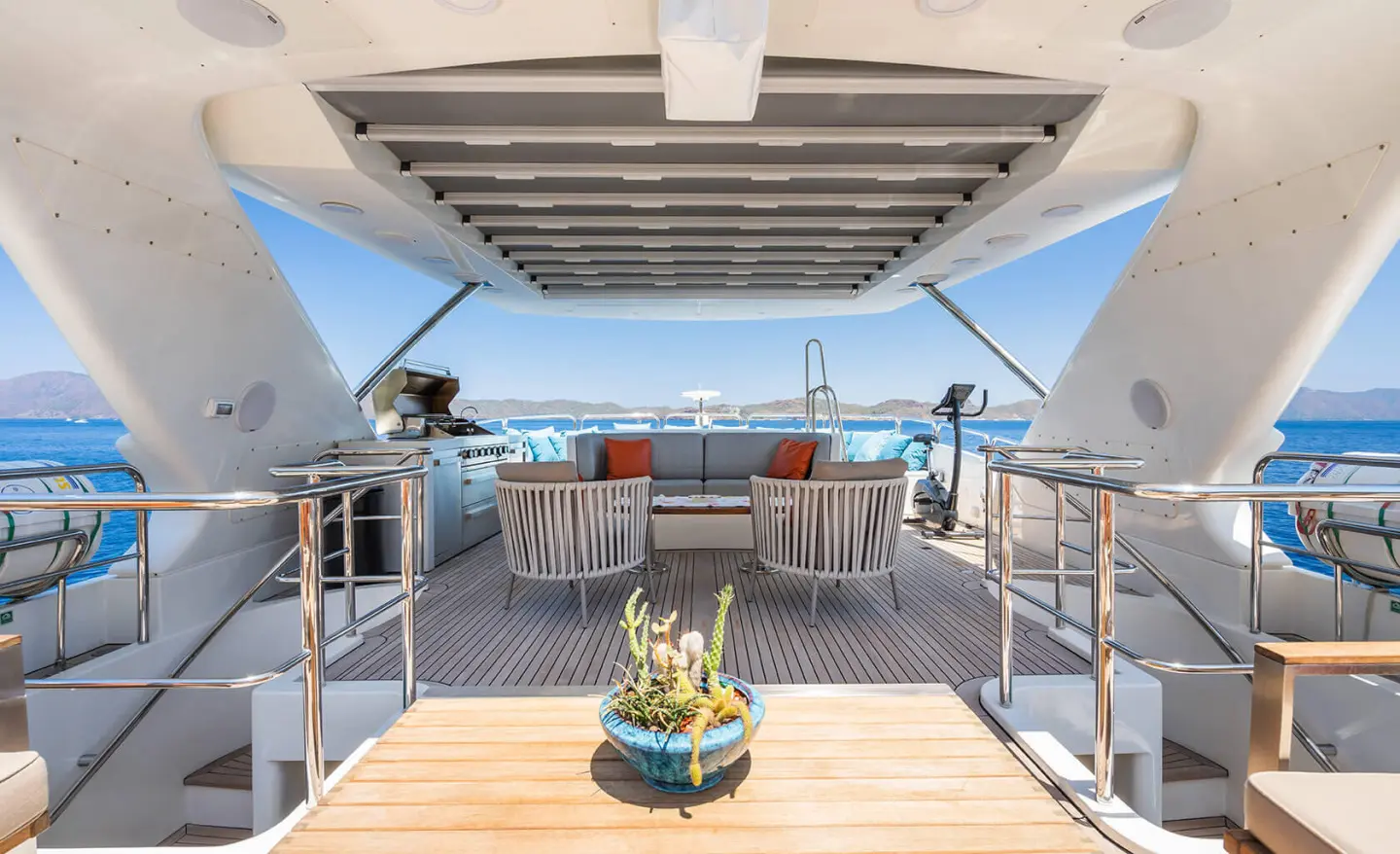 Amadea yacht sundeck with lounge chairs, wooden deck, and clear blue water