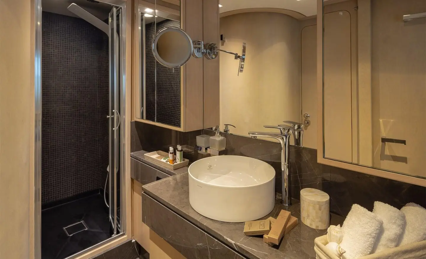 Boutique yacht bathroom with round sink, beige fixtures, and mirror