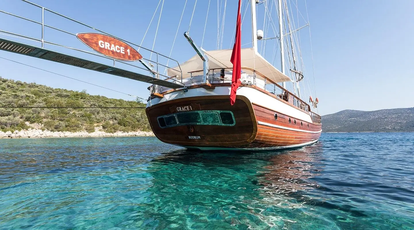 Grace 1 luxury gulet sailing boat anchored near clear turquoise sea at sunset