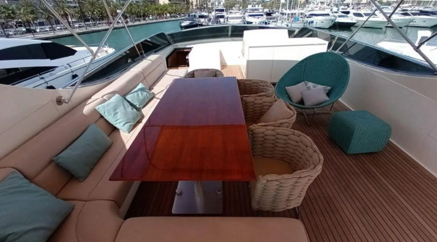 Miraval yacht deck with wooden table and cushioned seating on flybridge