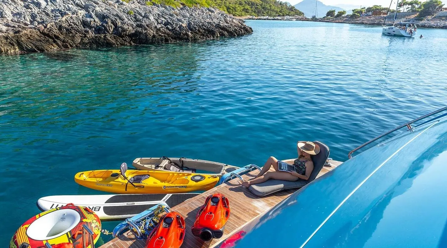 Sea Wolf motor yacht drawn up by a blue hull with people on deck and water toys nearby