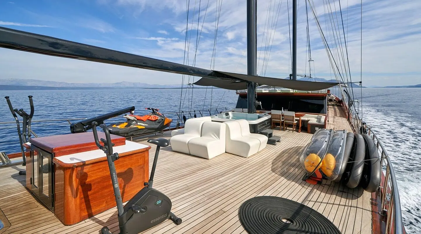 Stella Maris yacht deck at sunset with seating, drinks, and blue sea horizon