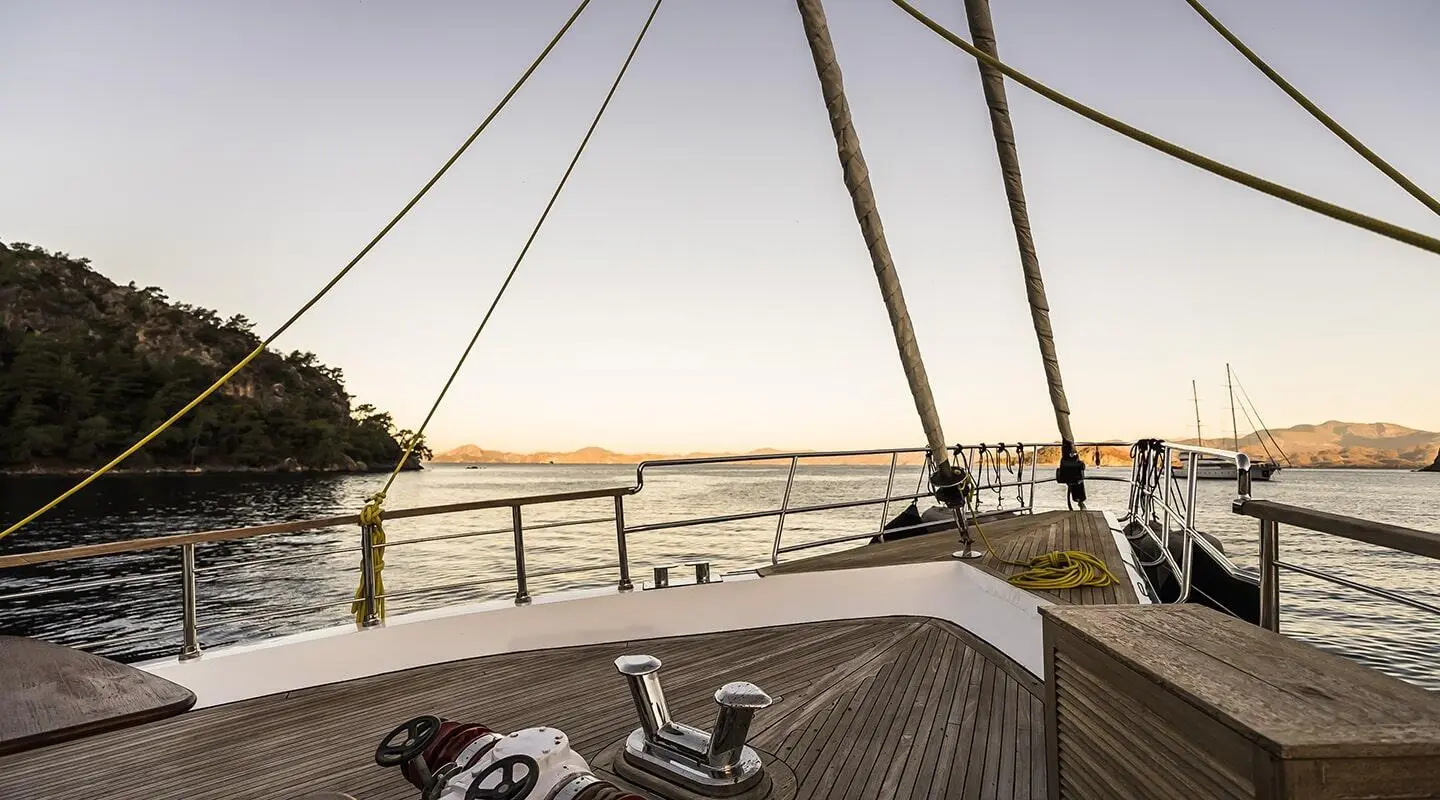Bow deck of Belgin Sultan gulet with rail, ropes, and sunlit harbor view