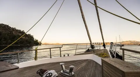 Bow deck of Belgin Sultan gulet with rail, ropes, and sunlit harbor view