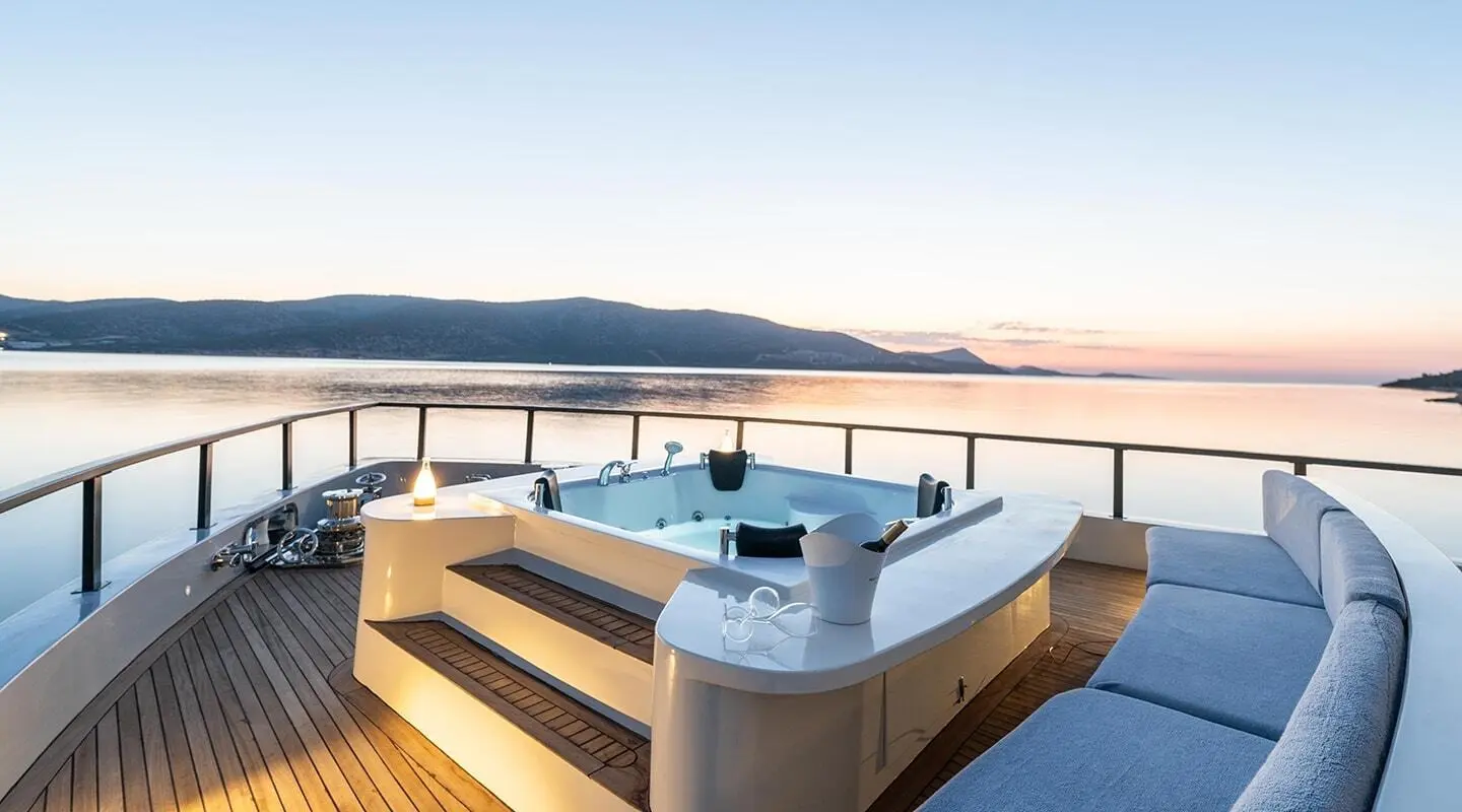 Calm Down yacht deck with jacuzzi, seating, and ocean view at sunset