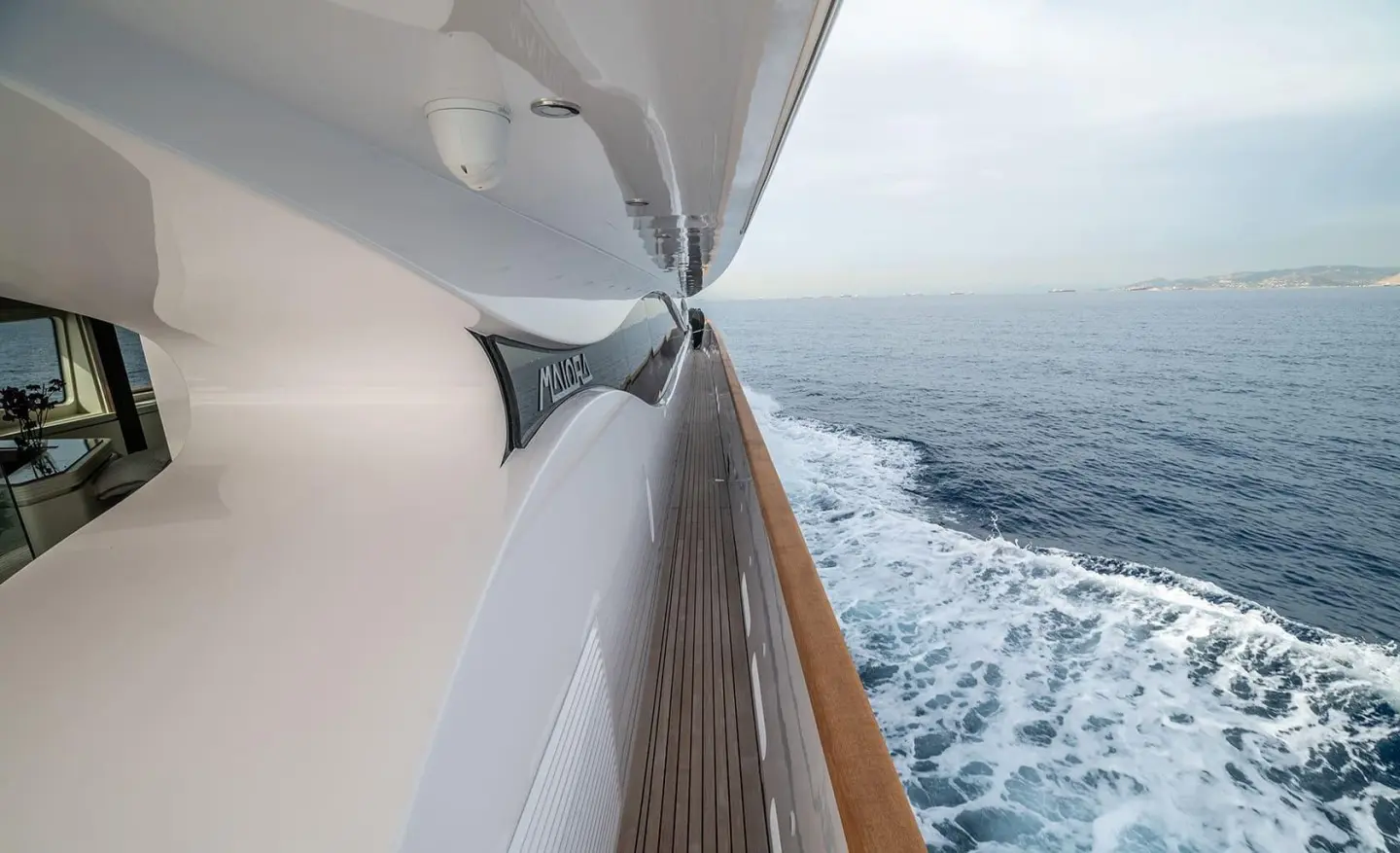 Pareaki II yacht side deck view with railing and ocean wake behind