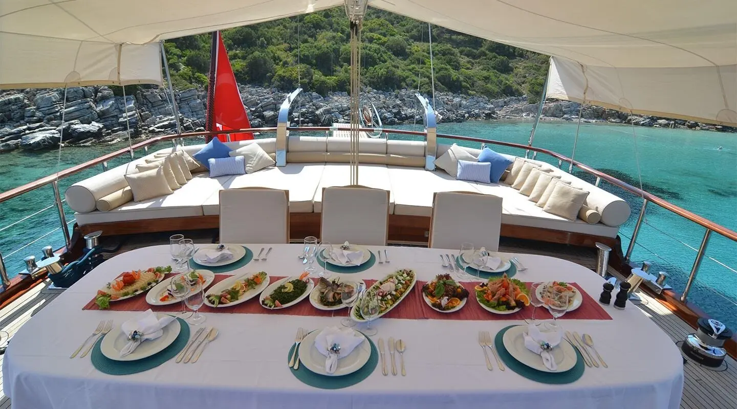 View from deck of Blue Heaven yacht with sunbeds, plates, and offshore boats