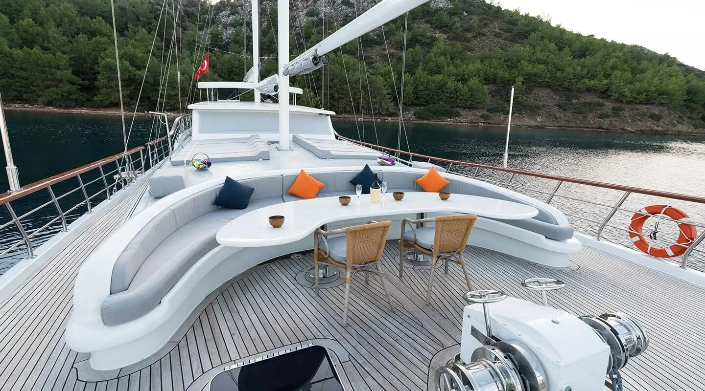 Vista Mare yacht deck with seating, orange towels, and rope railings at sunset