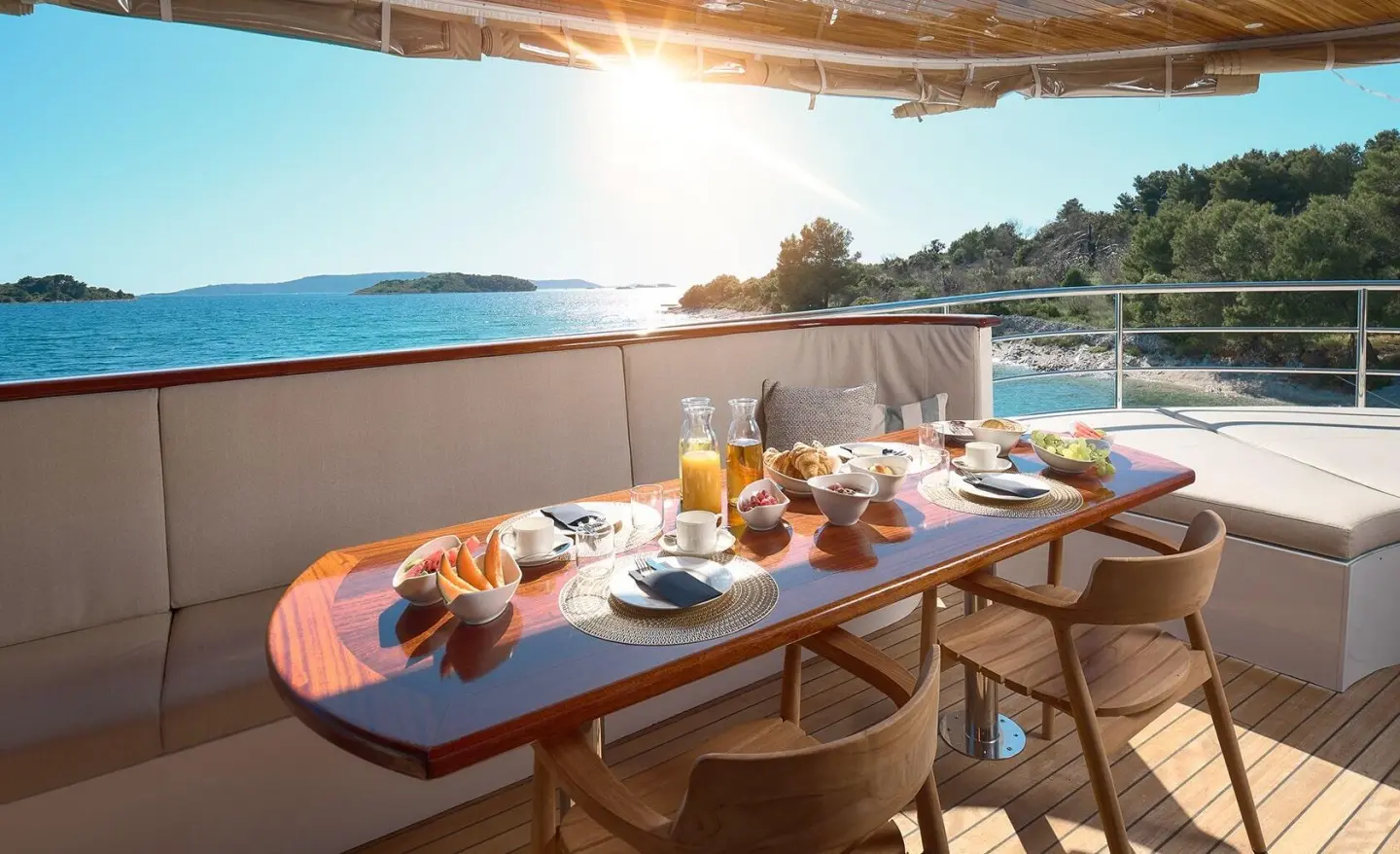 Bellezza yacht dining setup at sunset on deck with tableware and sea view