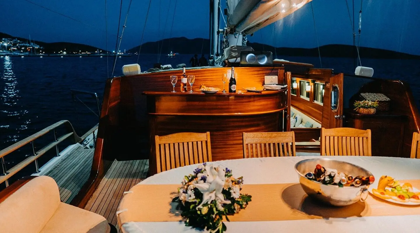 Sunset on Wicked Felina yacht with polished wooden deck and dining table