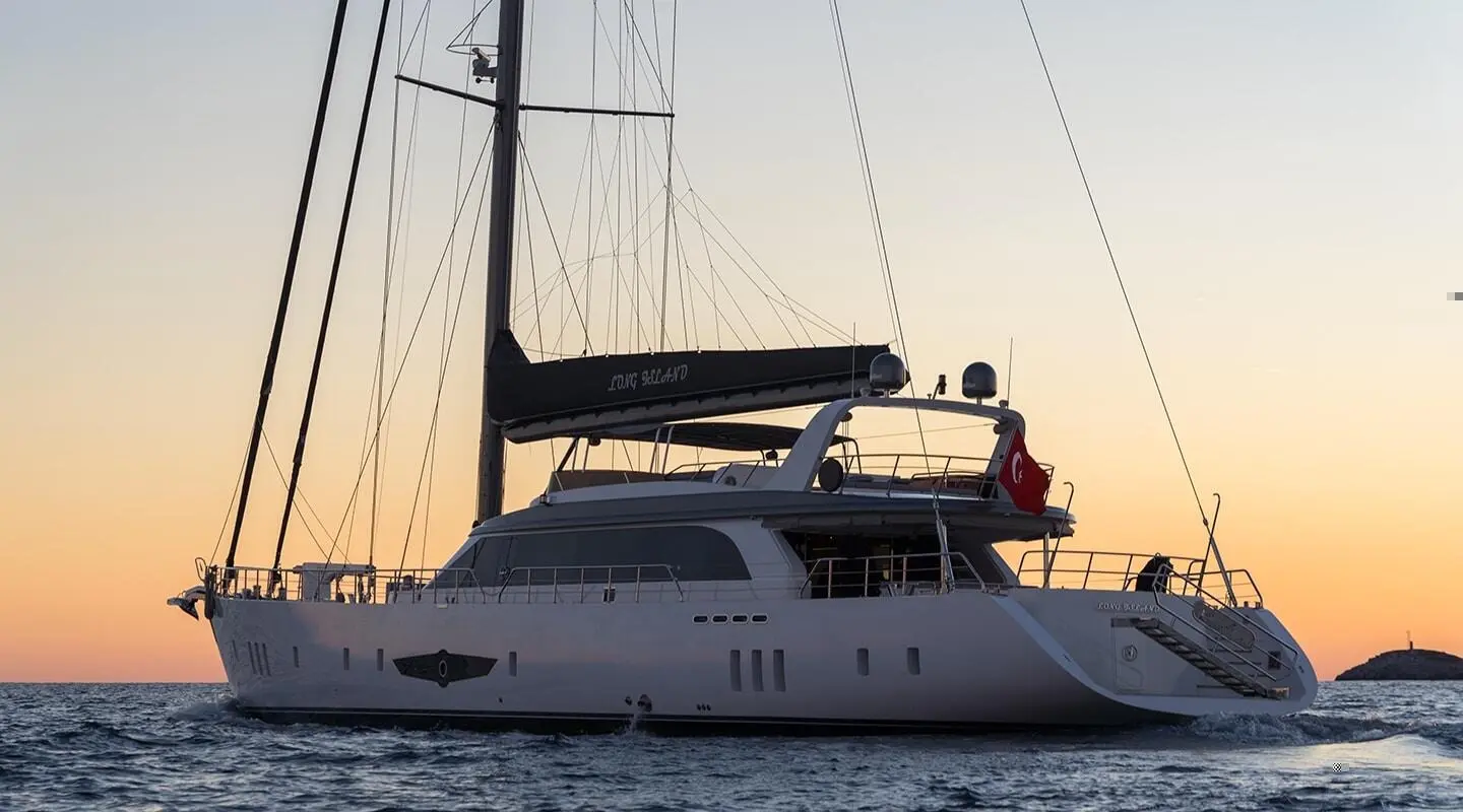 Sleek yacht Long Island at sunset showing stern, deck, and lifebuoys