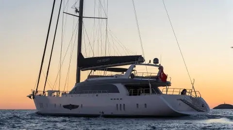 Sleek yacht Long Island at sunset showing stern, deck, and lifebuoys