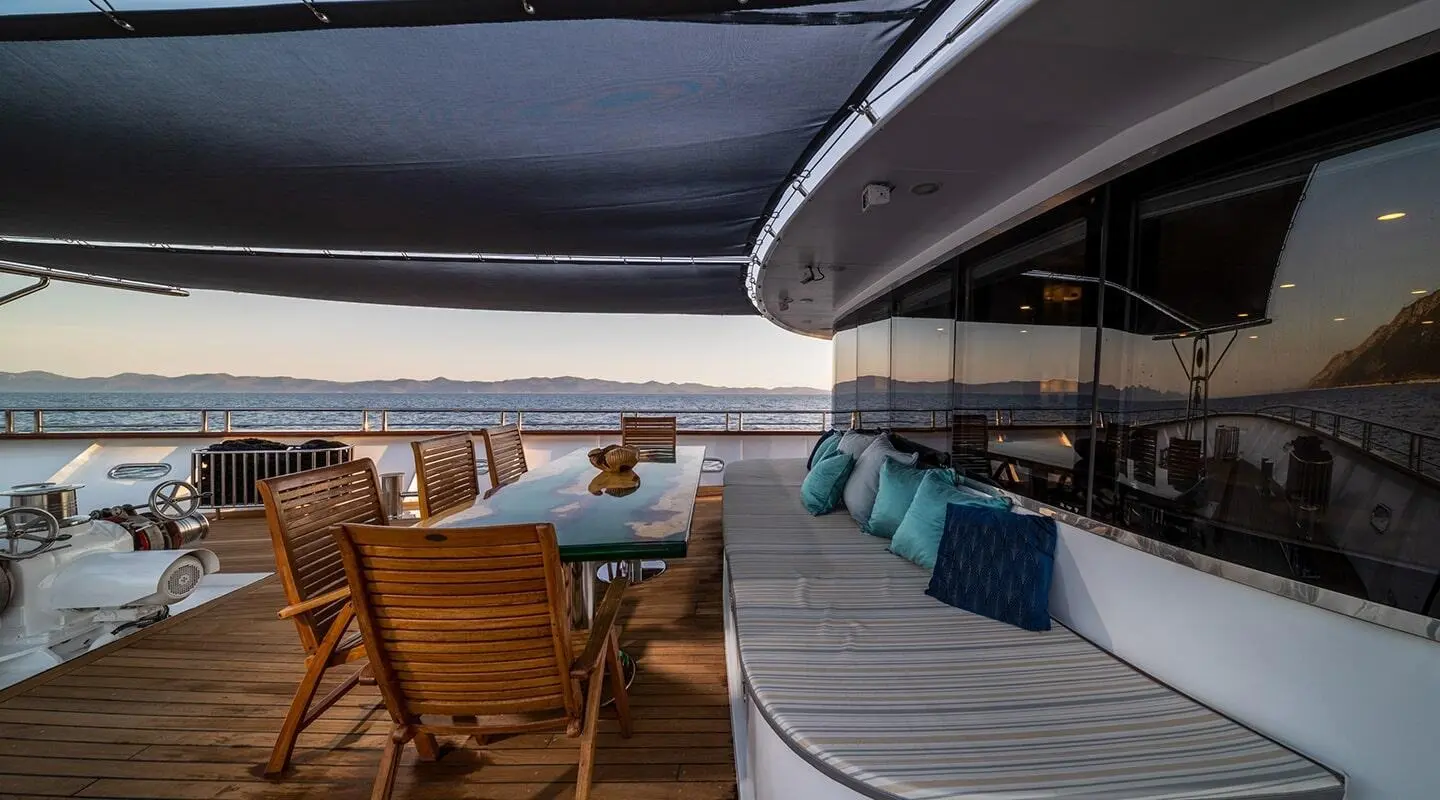Olimp luxury yacht deck with seating area, turquoise water beyond, sunny day