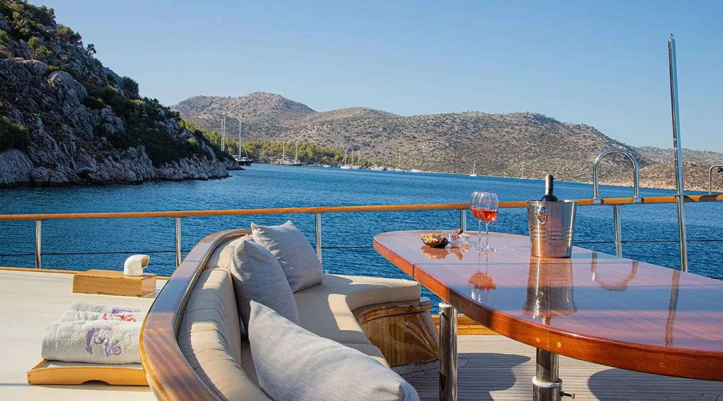 Derin Deniz yacht deck at sunset with orange water calm sea and hills