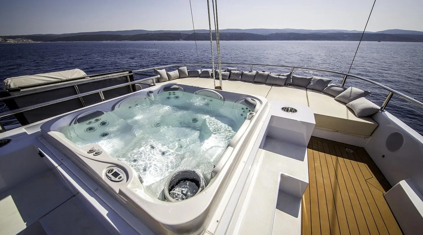 Omnia yacht on blue ocean with a large Jacuzzi aft deck and plush seating
