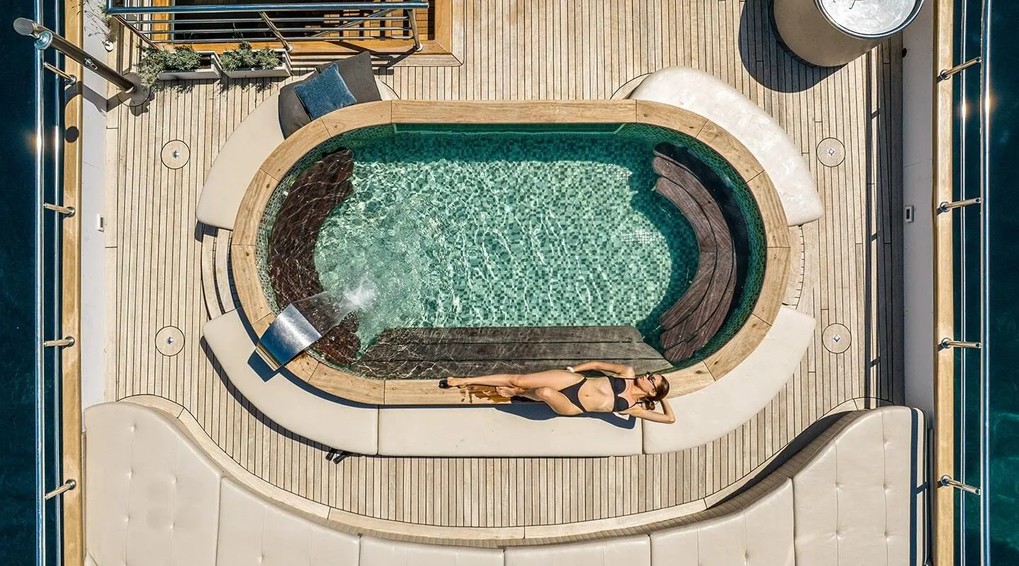 Bird's-eye view of Bella yacht pool deck with loungers and sunbathers