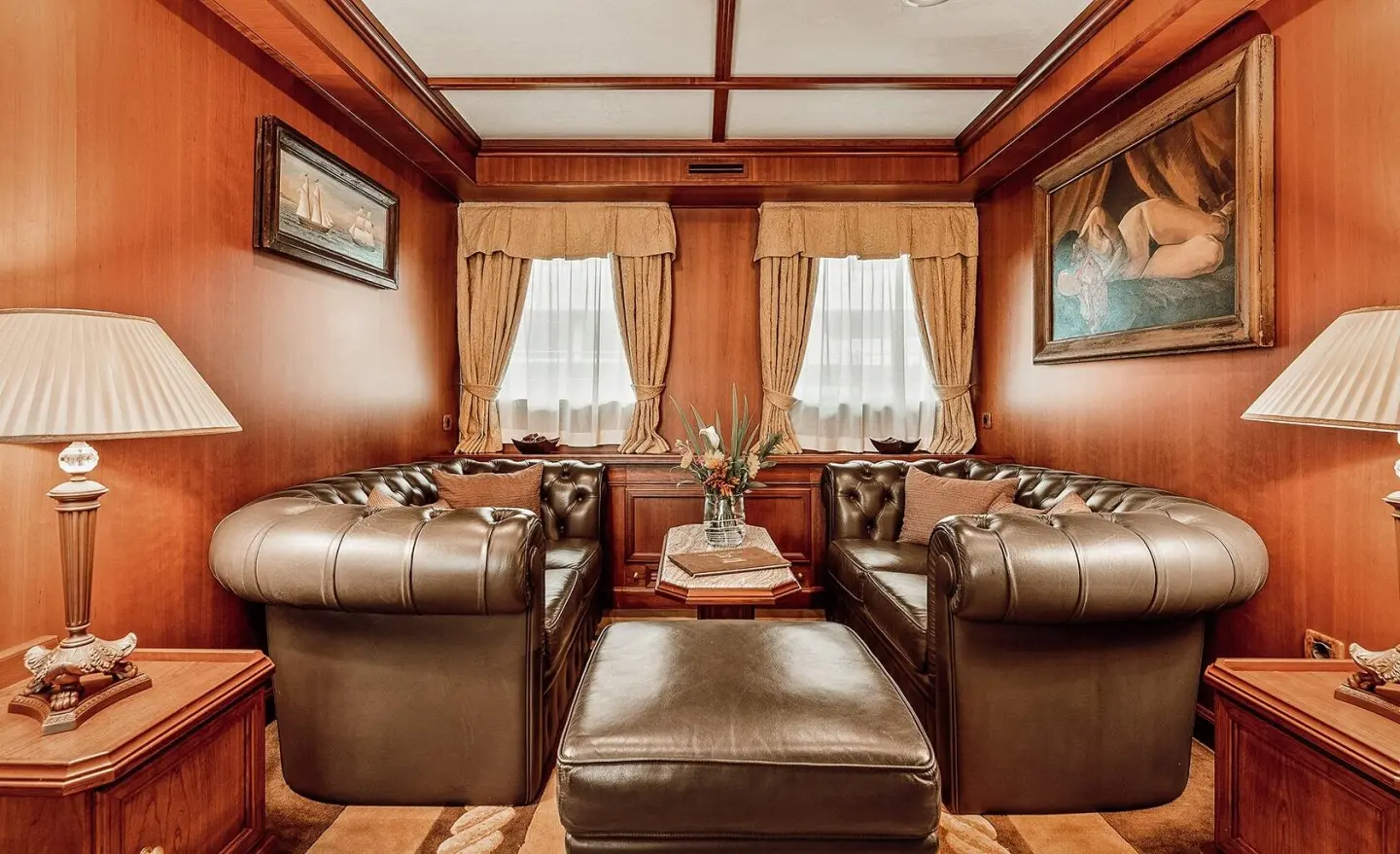 Seagull II yacht interior with brown wood cabinetry and two leather sofas