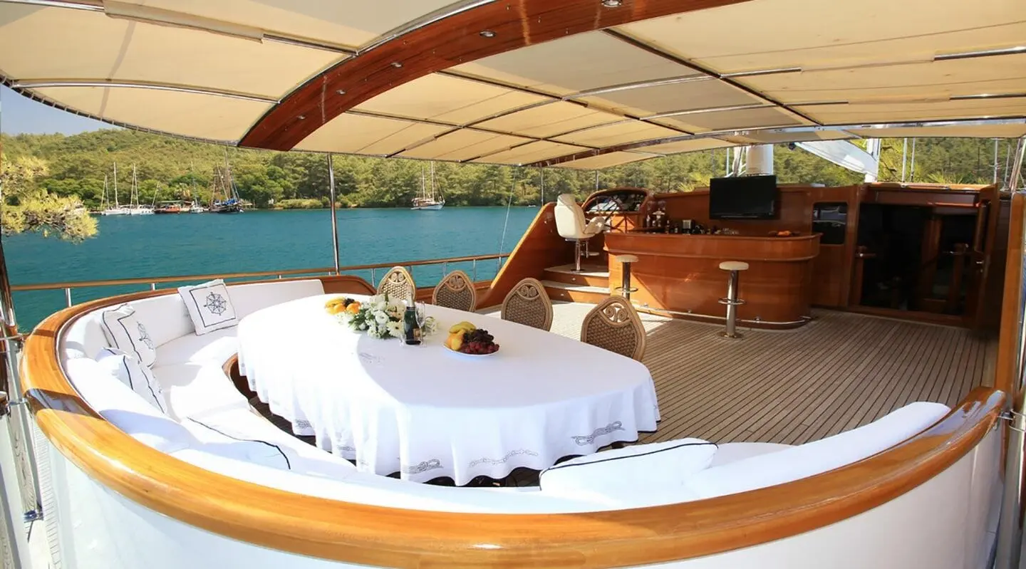 Yacht Kaya Guneri 5 aft deck with curved seating, white cushions, and shaded area