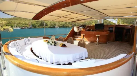 Yacht Kaya Guneri 5 aft deck with curved seating, white cushions, and shaded area