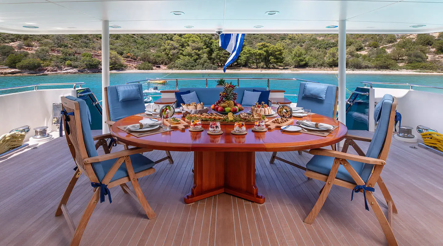 Magix yacht dining area set for sunset, table with chairs on deck