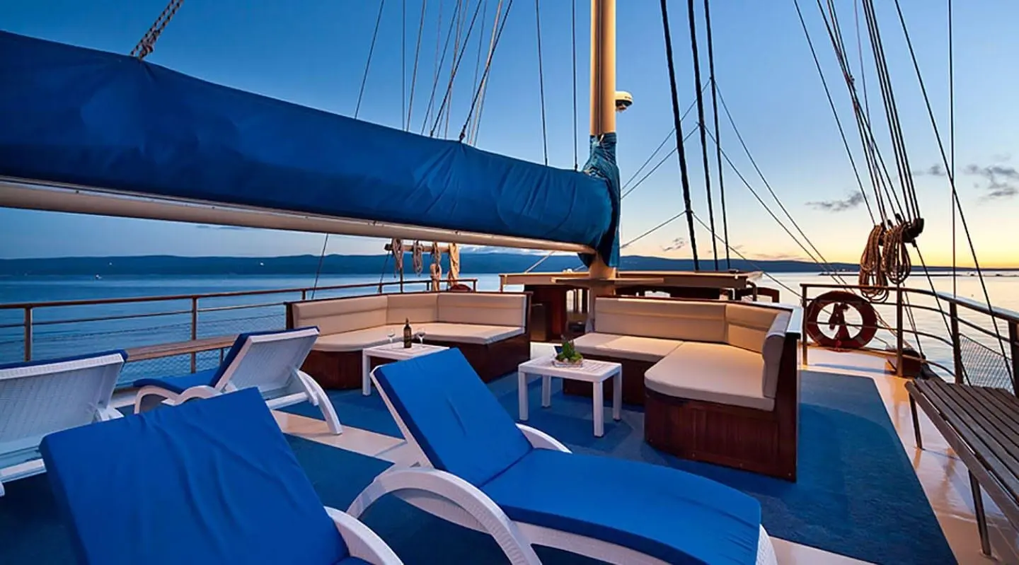 Upper deck view of Tajna Mora gulet with blue sun loungers and railing