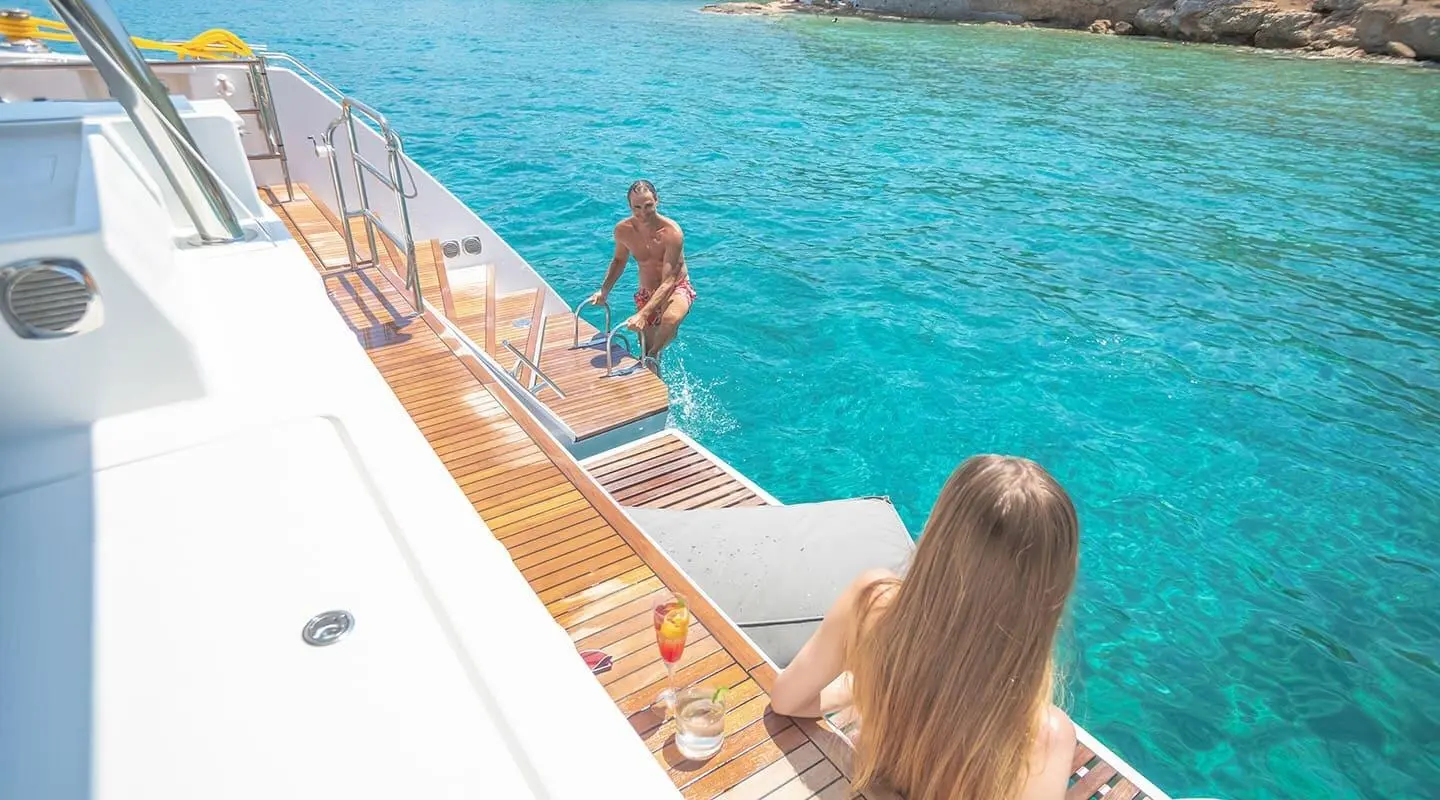 Deck view of D2 luxury yacht with people by the pool and blue sea