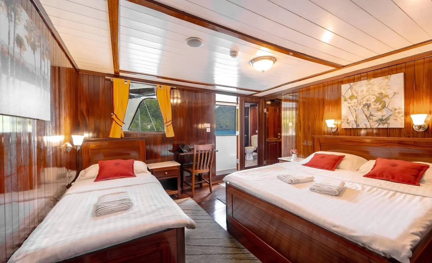 Cesarica luxury yacht interior with two cushioned beds, wood paneling, and warm lighting