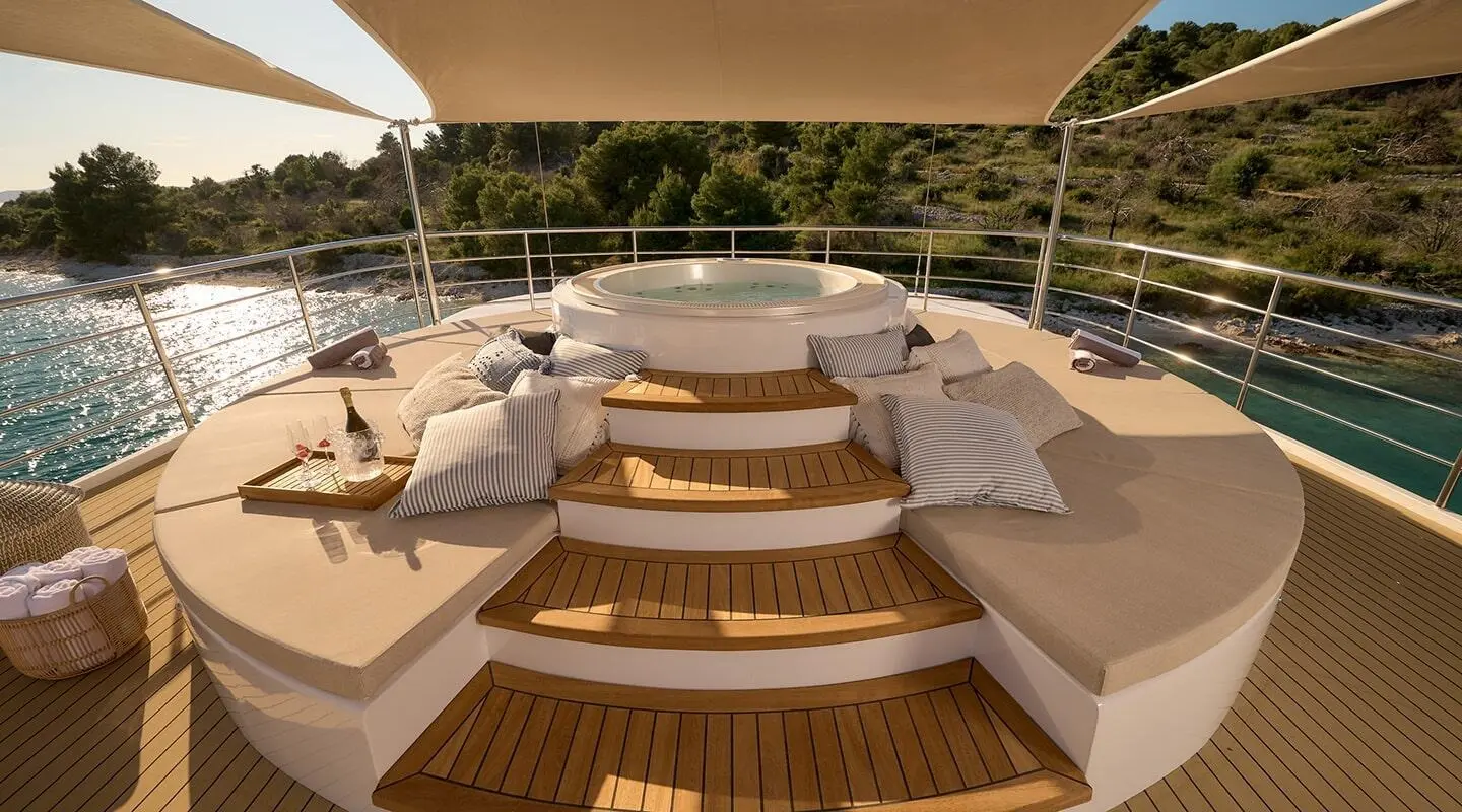 Sunlit deck lounge surrounding a central jacuzzi on the luxury motor yacht Bellezza