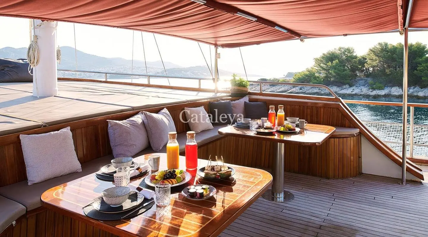 Cataleya yacht terrace with dining setup on deck at sunset aboard luxury gulet