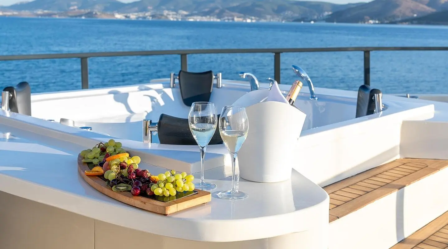 Calm Down yacht deck with Jacuzzi, white seating, and blue sea backdrop